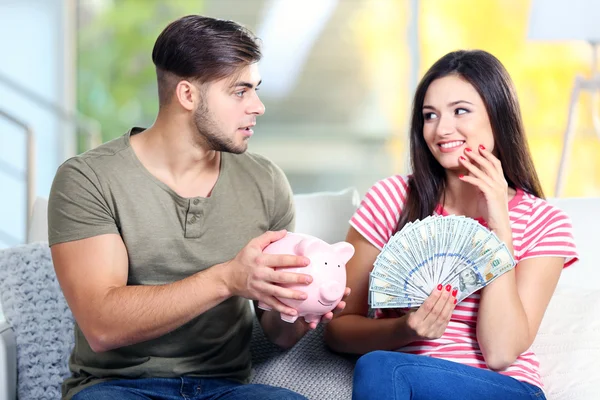 Lyckliga par med pengar från Sparbössa — Stockfoto