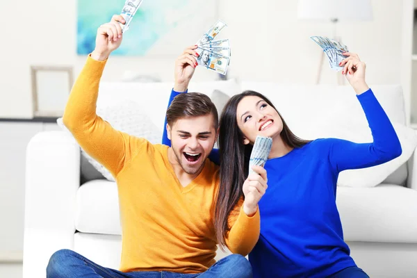Gelukkige paar in een kamer met geld — Stockfoto