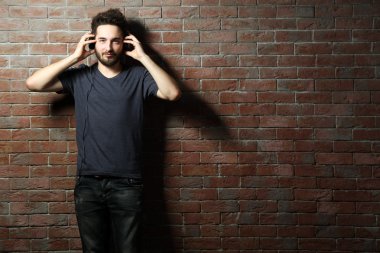 Kulaklıkla müzik dinleyen genç adam. 