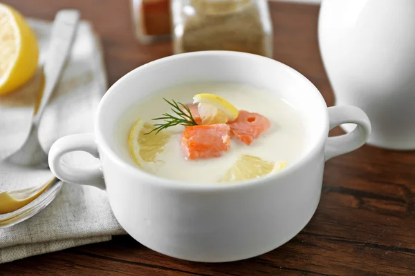 Heerlijke zalm crème soep op houten tafel, die geserveerd met gesneden citroen en specerijen — Stockfoto