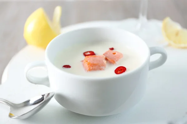 Tasty salmon cream soup, wine and lemon on wooden table, close up — Stock Photo, Image