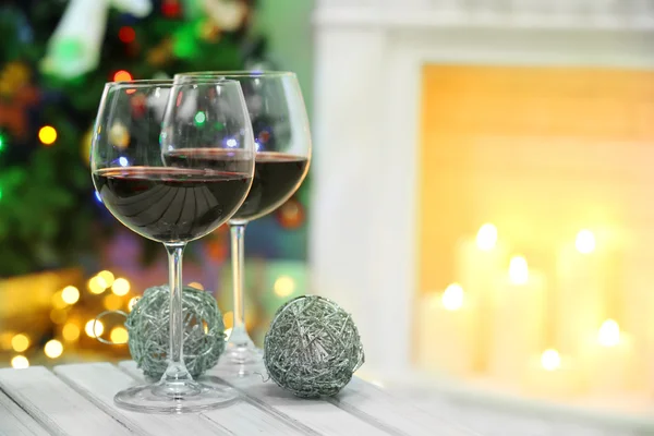 Dos copas de vino con decoración de Navidad en el fondo de la chimenea —  Fotos de Stock