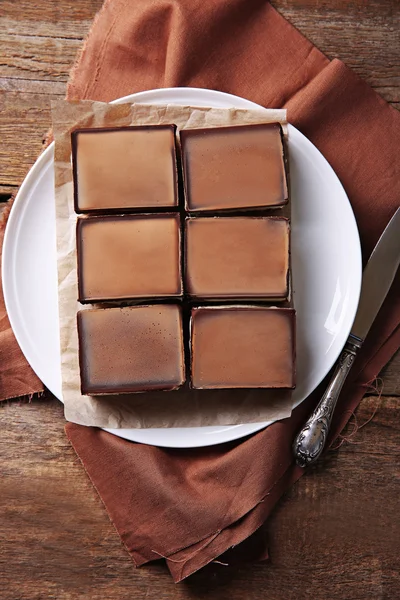 Heerlijke chocolade brownies op plaat, op houten achtergrond — Stockfoto