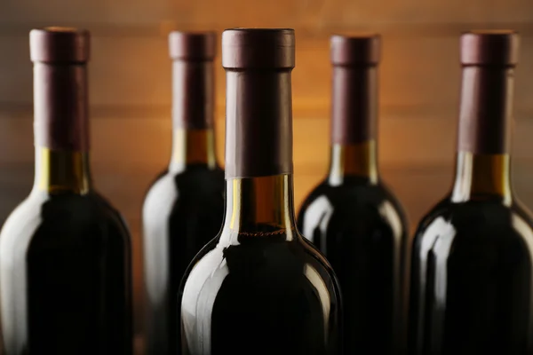 Wijnflessen op houten ondergrond, close up — Stockfoto