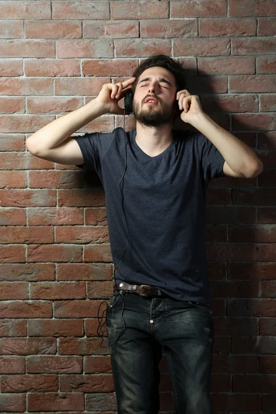 Kulaklıkla müzik dinleyen genç adam. — Stok fotoğraf