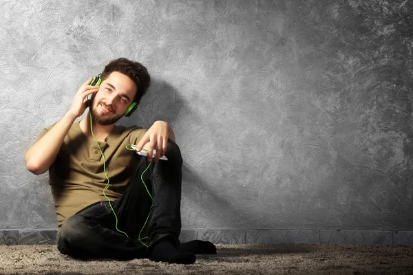 Joven escucha música con auriculares —  Fotos de Stock