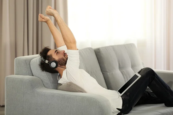 Joven escucha música con auriculares — Foto de Stock