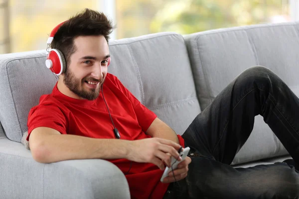 Jovem ouve música com fones de ouvido — Fotografia de Stock