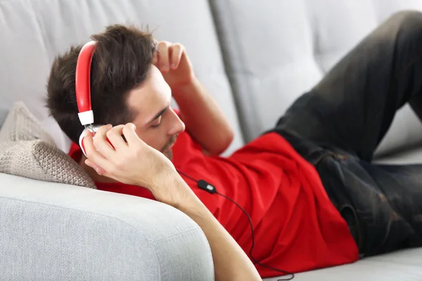 Młody człowiek słucha muzyki w słuchawkach — Zdjęcie stockowe