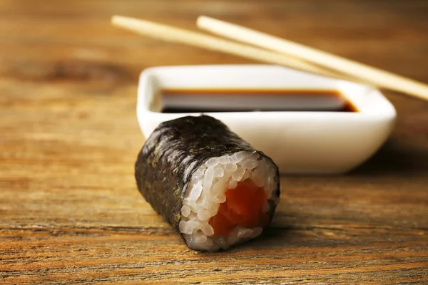 Roll with sauce and sticks on wooden table close up — Stock Photo, Image