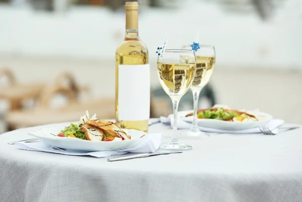 Heerlijke salade met wijn op witte geserveerd tabel — Stockfoto