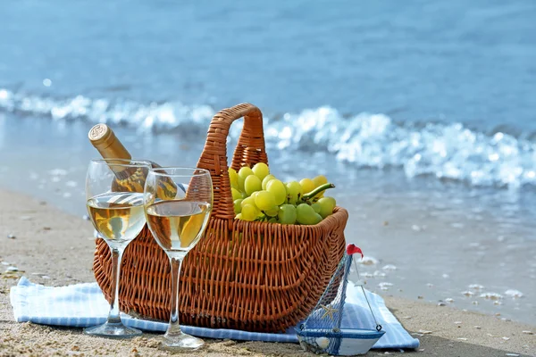Panier pique-nique avec bouteille de vin sur la plage de sable — Photo