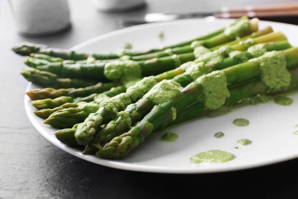テーブルの上のグリーン ソースで新鮮なアスパラガス料理をクローズ アップ — ストック写真