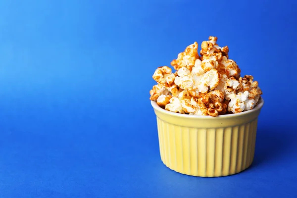 Sweet caramel popcorn on blue background — Stock Photo, Image