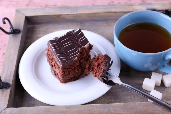 लाकडी पार्श्वभूमीवर चहा आणि चॉकलेट केक एक कप टेबल सेवा केली जवळ-अप — स्टॉक फोटो, इमेज