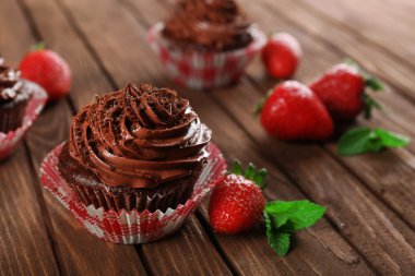 Çikolata cupcakes ve ahşap arka plan üzerinde çilek