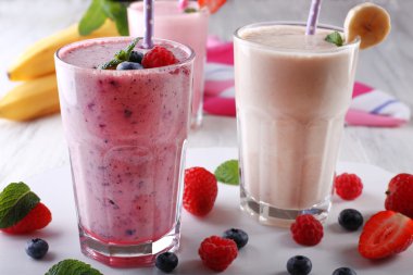 Milkshakes hafif ahşap arka plan üzerinde çilek ile yakın çekim