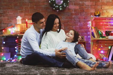 Mutlu aile, dekore edilmiş Noel odasında.