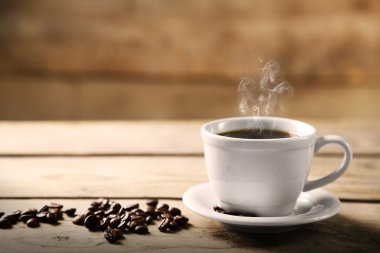 Fincan kahve ve kahve taneleri ahşap arka plan üzerinde