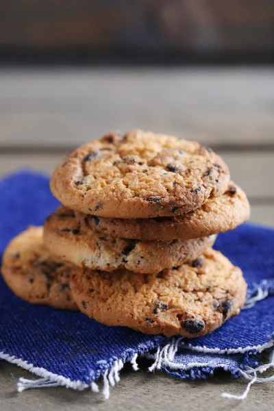 Soubory cookie s čokoládové drobky na dřevěný stůl rozmazané pozadí, zblízka — Stock fotografie