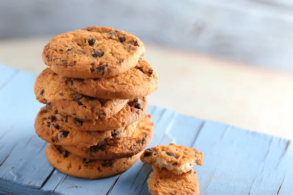 Cookies met chocolade broodkruimels op blauwe houten tafel tegen onscherpe achtergrond, close-up — Stockfoto