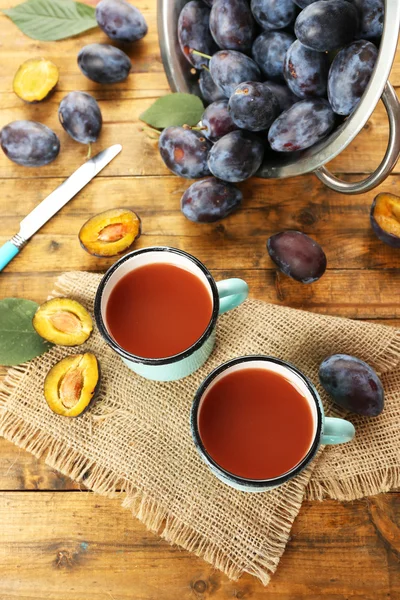 Plum Juice in mugs with fresh fruits — Stock Photo, Image