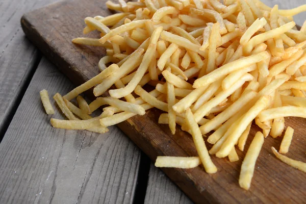 Batatas fritas francesas na tábua de corte — Fotografia de Stock