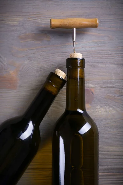 Dos botellas de vino y sacacorchos sobre fondo de madera púrpura —  Fotos de Stock