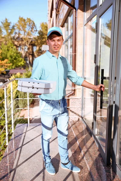 Pizza leverans boy håller rutor med pizza, utomhus — Stockfoto