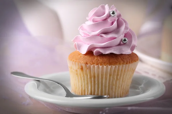 Tasty cupcake on saucer, on light background — Stock Photo, Image