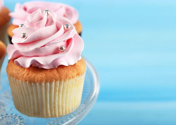 Tasty cupcake on color wooden background — Stock Photo, Image