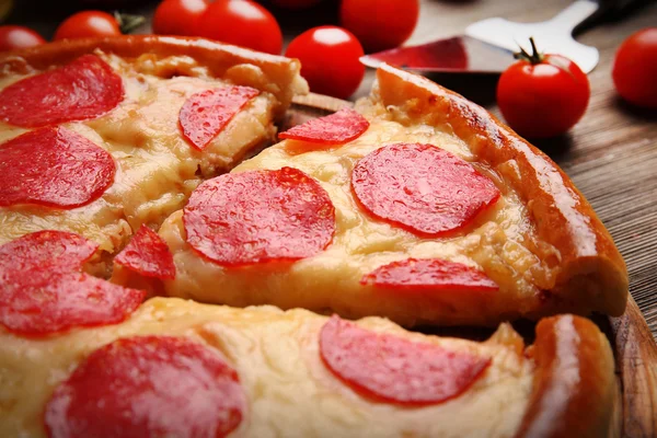 Pizza chaude savoureuse avec salami sur fond en bois, gros plan — Photo