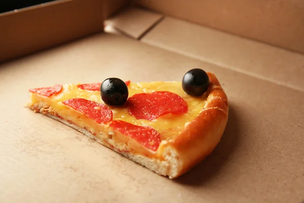 Lahodný chutný kousek pizzy na krabici — Stock fotografie
