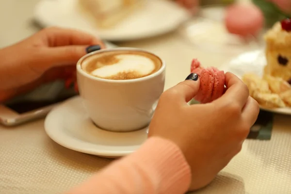 カフェでコーヒーとケーキのカップを持つ女性 — ストック写真