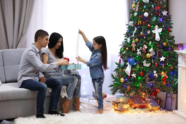 Liefdevolle familie: moeder, vader en dochter in de ingerichte kamer voor Kerstmis — Stockfoto