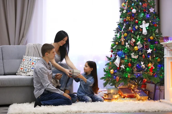 Famiglia amorevole: madre, padre e figlia nella stanza decorata di Natale — Foto Stock