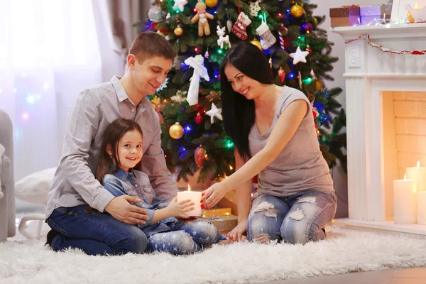Mutlu aile birlikte dekore edilmiş Noel odasında elinde mum tutun — Stok fotoğraf
