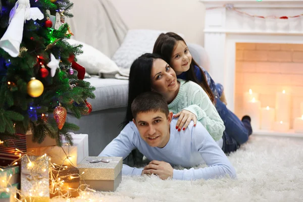 Familia feliz en el suelo con regalos en la habitación de Navidad decorada —  Fotos de Stock