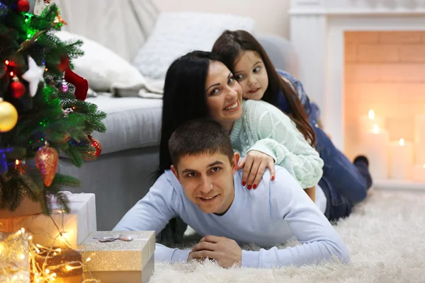 Familia feliz en el suelo con regalos en la habitación de Navidad decorada —  Fotos de Stock