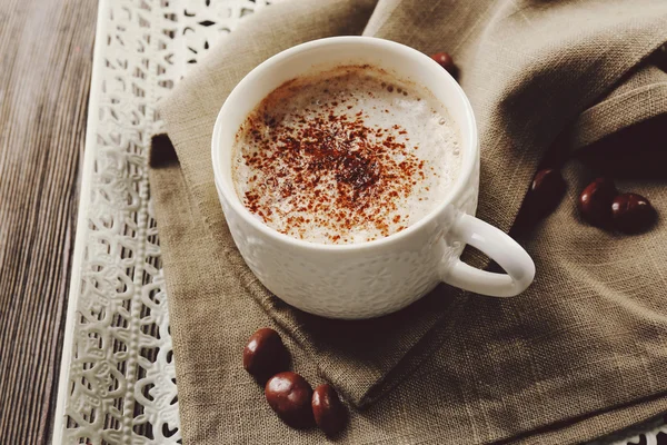 Cup of hot cacao with sweets on cotton serviette