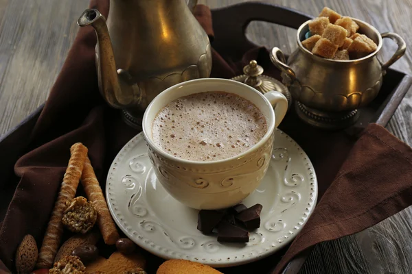 Vintage cup of cacao on tray with silver service and cookies