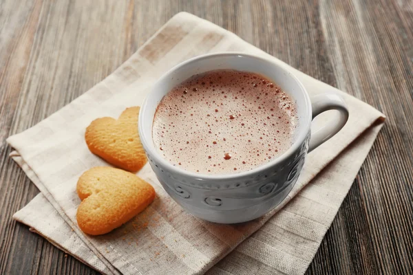 Tasse heißen Kakao mit herzförmigen Keksen auf Baumwollserviette — Stockfoto