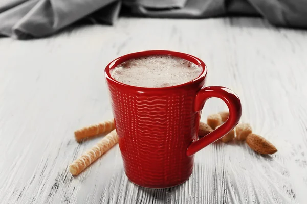 Red cup of hot cacao and sweets  on wooden background — Stock Photo, Image