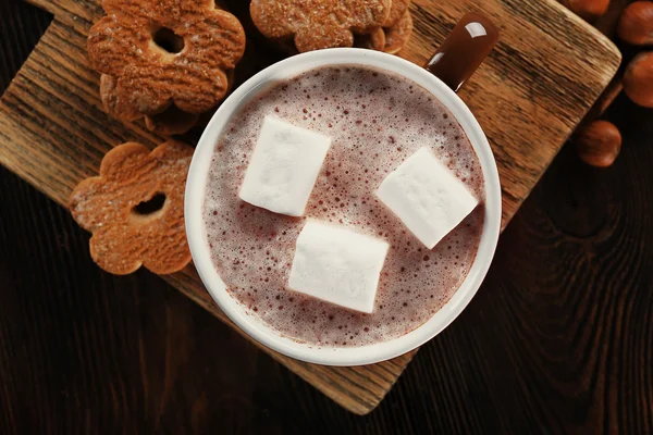 Tasse heißen Kakao mit Keksen und Nüssen auf Holzplatte, Nahaufnahme — Stockfoto