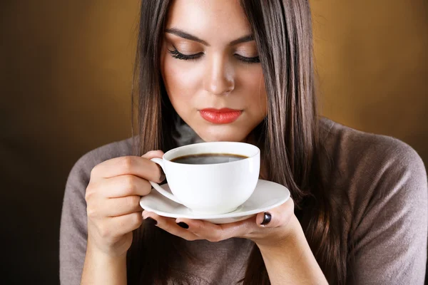 Woman holds cup of coffee and saucer in hands, close up — Stock Photo, Image