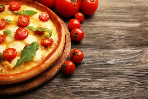 Pizza Margherita con rucola, pomodori tavolo in legno — Foto Stock