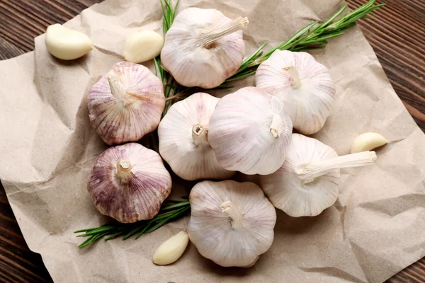 Zusammensetzung von Knoblauch und Rosmarin auf dem Papier, Nahaufnahme — Stockfoto