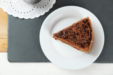 Açık renkli ahşap masaya üzerinde çikolatalı pasta dilimlenmiş