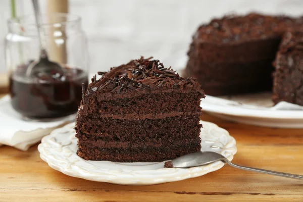 Açık renkli ahşap masaya üzerinde çikolatalı pasta dilimlenmiş — Stok fotoğraf