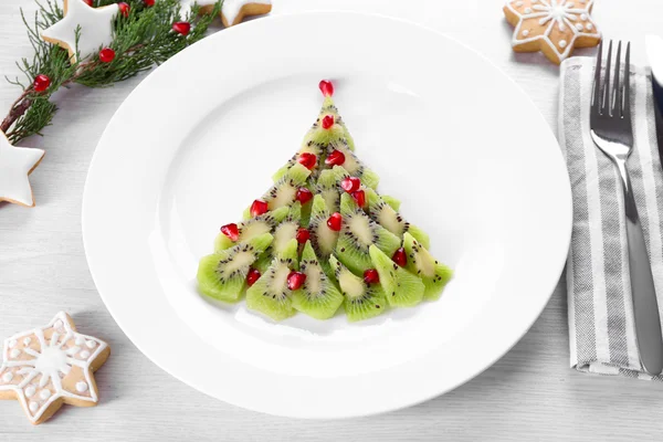 Christmas fir tree made from kiwi, on plate, close up — Stock Photo, Image